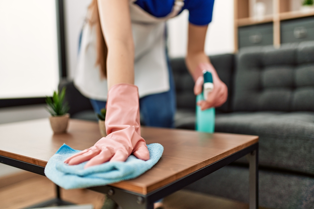 Person dusting coffee table