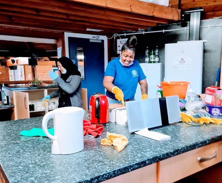 Two people cleaning a kitchen space